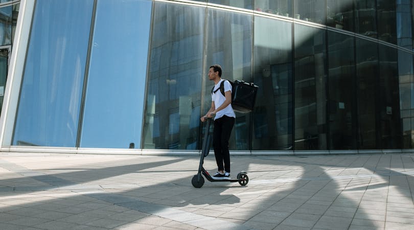 Hombre en patinete por la vía pública.